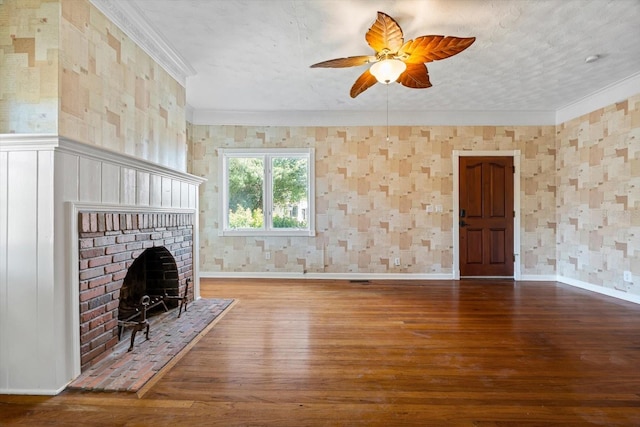 unfurnished living room featuring ceiling fan, crown molding, wood-type flooring, a textured ceiling, and a fireplace