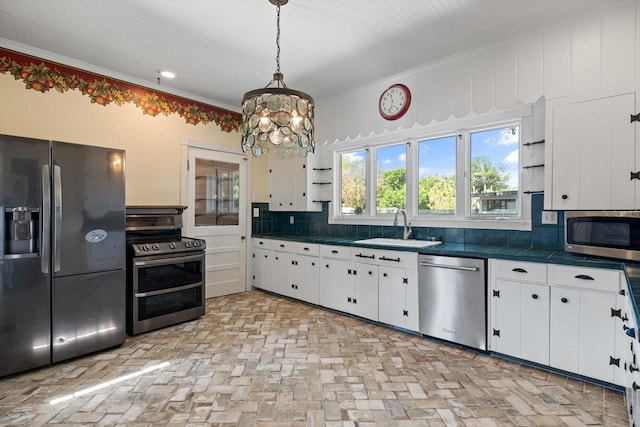 kitchen featuring pendant lighting, sink, white cabinetry, and stainless steel appliances