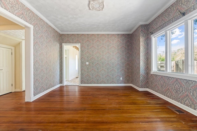 empty room featuring ornamental molding and hardwood / wood-style flooring