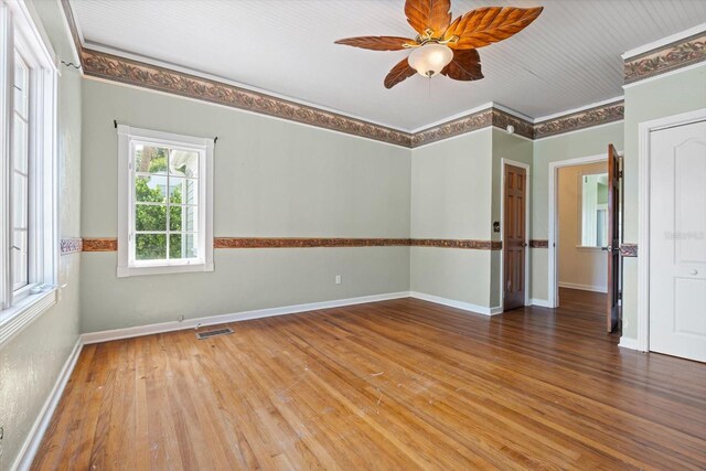 spare room featuring ceiling fan, wood-type flooring, and crown molding