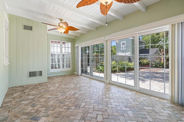 unfurnished sunroom featuring beam ceiling