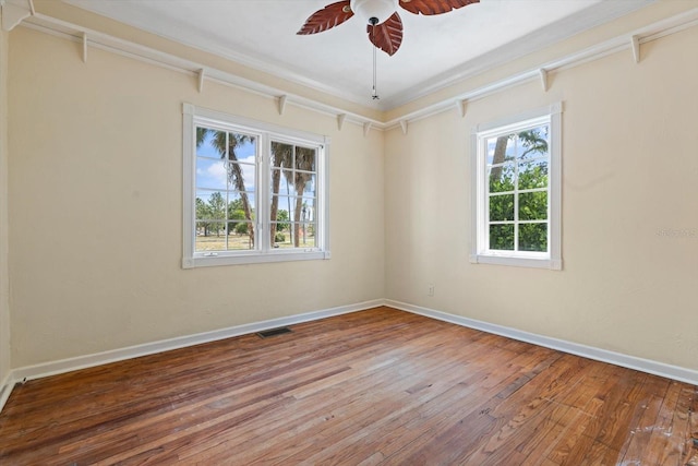 empty room with ceiling fan, hardwood / wood-style floors, and crown molding