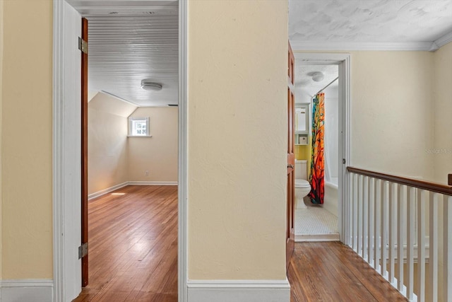 hallway with ornamental molding and hardwood / wood-style flooring