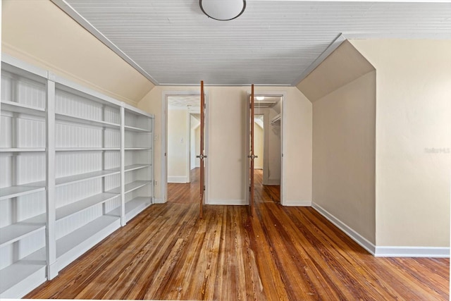 unfurnished room featuring hardwood / wood-style flooring and lofted ceiling