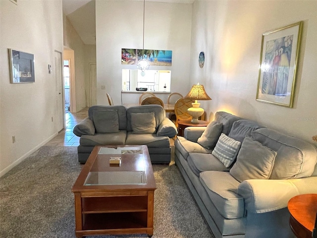 living room with dark colored carpet, high vaulted ceiling, and a notable chandelier