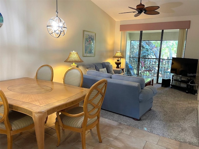 dining area with lofted ceiling, ceiling fan with notable chandelier, and light tile floors