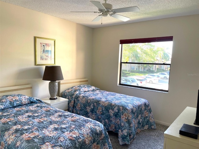 bedroom with carpet flooring, ceiling fan, and a textured ceiling