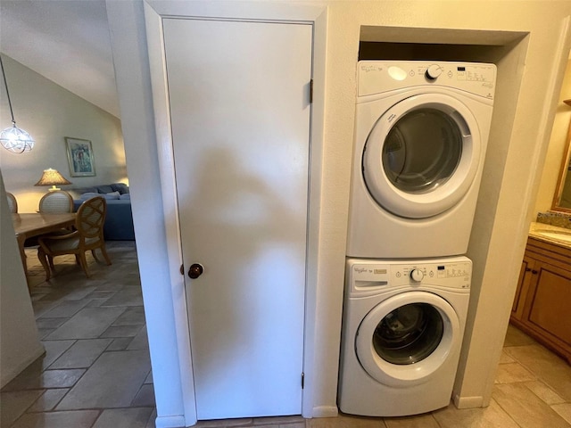 laundry room featuring light tile flooring and stacked washer / drying machine