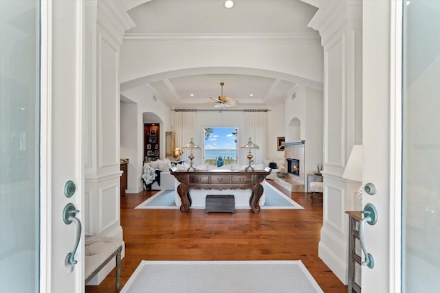 entrance foyer with ceiling fan, wood-type flooring, and ornamental molding