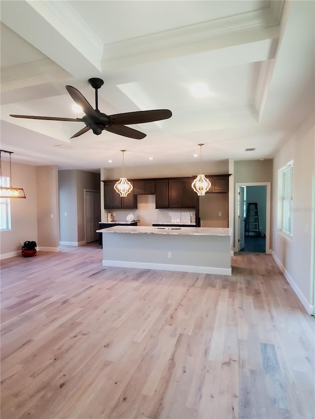 kitchen featuring light countertops, dark brown cabinets, baseboards, and light wood finished floors