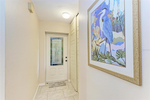 entryway featuring a textured ceiling and light tile floors