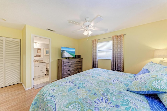 bedroom featuring a closet, light hardwood / wood-style floors, ceiling fan, and ensuite bathroom