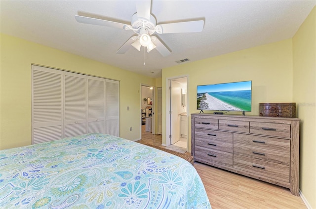 bedroom featuring ensuite bath, a closet, ceiling fan, and light hardwood / wood-style flooring