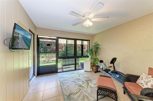 sitting room featuring light tile floors, ceiling fan, and a healthy amount of sunlight