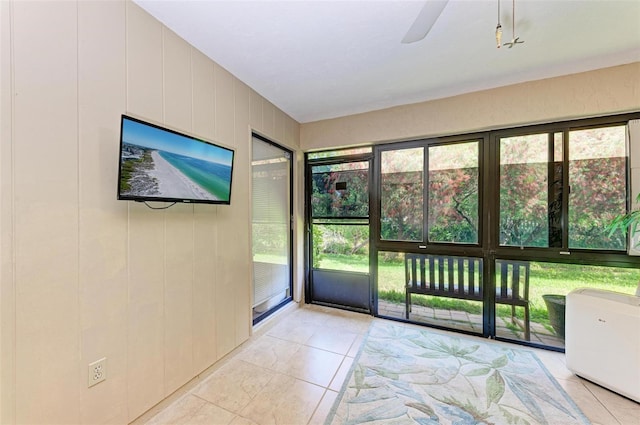 doorway with ceiling fan and light tile floors