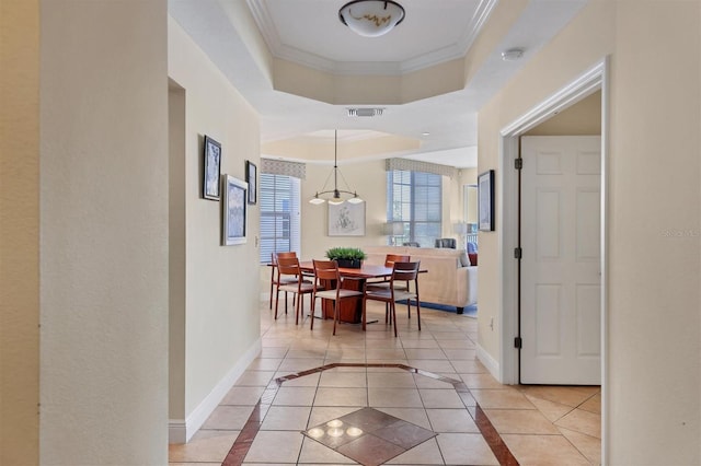 hallway featuring ornamental molding, light tile patterned floors, and a chandelier