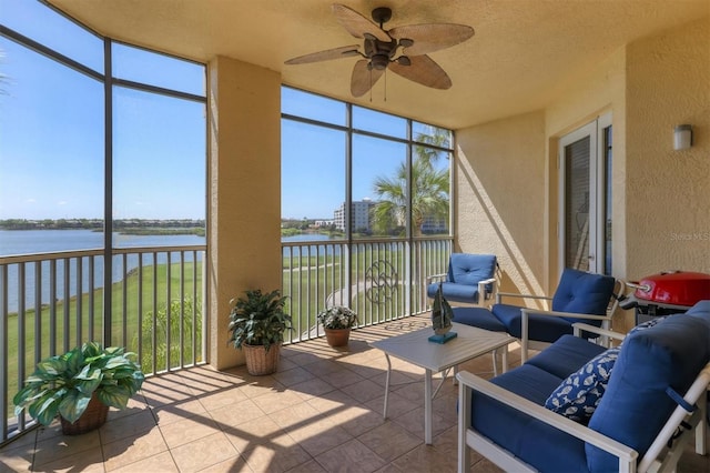 sunroom / solarium with a water view and ceiling fan