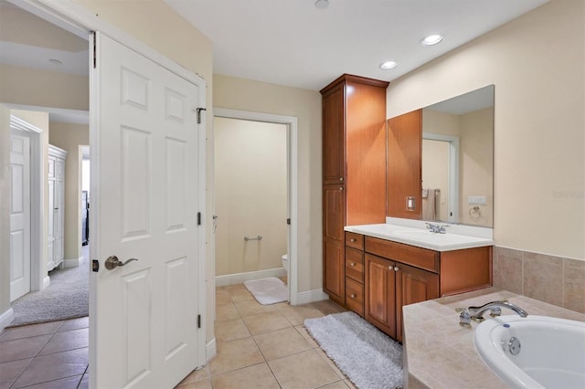 bathroom with tile patterned flooring, vanity, toilet, and a bath