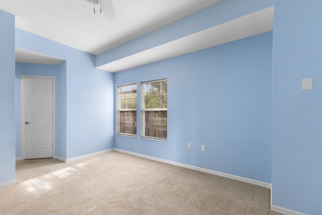 spare room featuring light colored carpet and ceiling fan