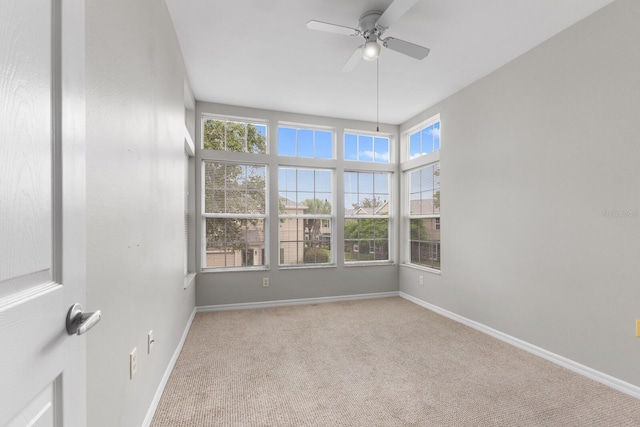 empty room featuring ceiling fan and light colored carpet