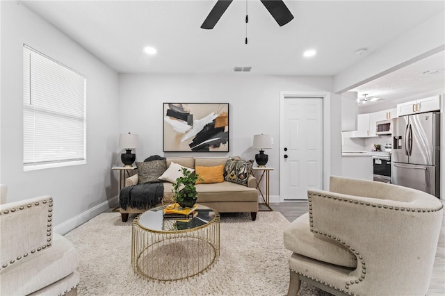 living room with ceiling fan and light hardwood / wood-style floors