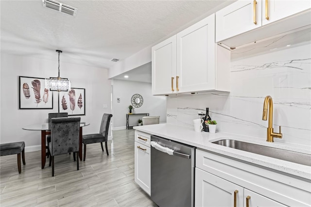 kitchen featuring a textured ceiling, dishwasher, hanging light fixtures, and white cabinetry