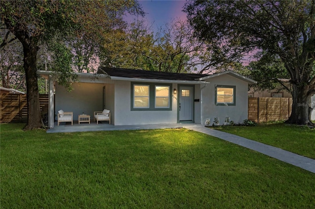 view of front of property featuring a lawn and a patio