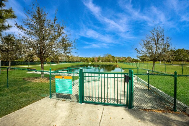 view of gate with a lawn and a water view