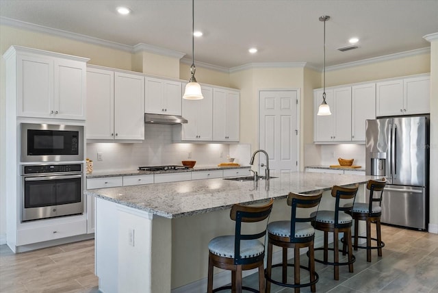 kitchen featuring white cabinetry, sink, appliances with stainless steel finishes, and an island with sink