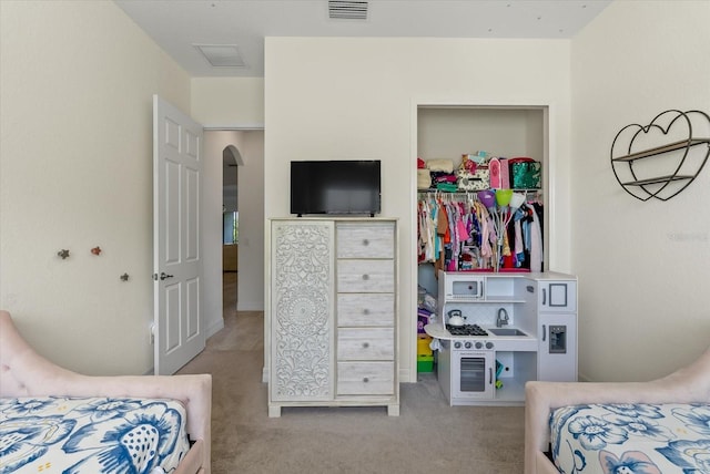 bedroom with light carpet and a closet