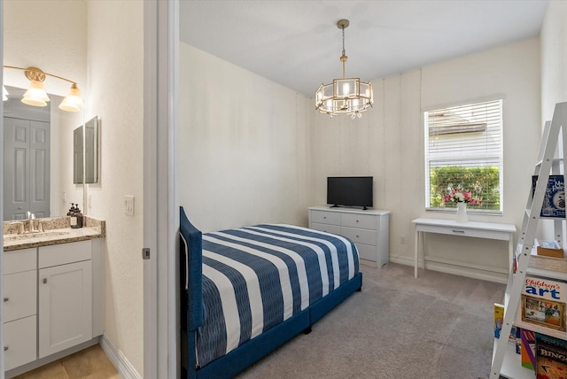 bedroom with sink, light carpet, and a chandelier