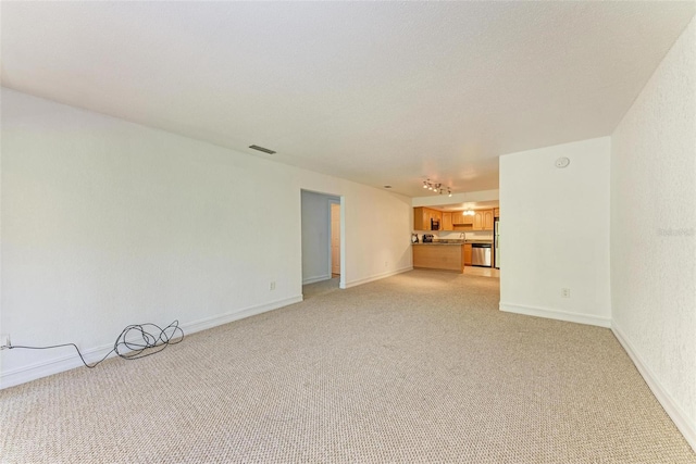 unfurnished living room featuring light colored carpet