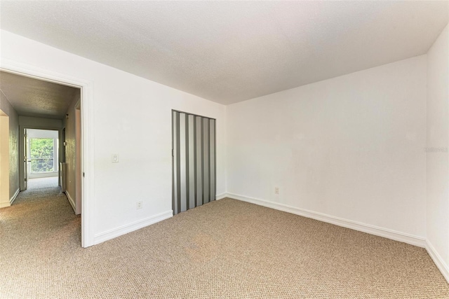 carpeted spare room featuring a textured ceiling