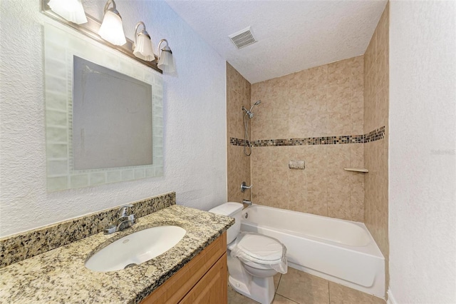 full bathroom with vanity, tiled shower / bath combo, a textured ceiling, tile flooring, and toilet