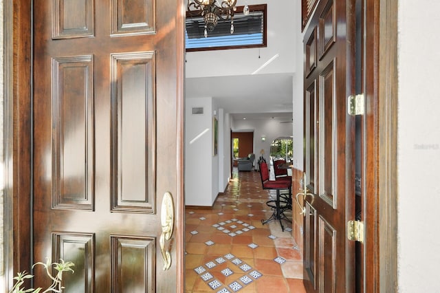 entryway featuring light tile floors and a chandelier