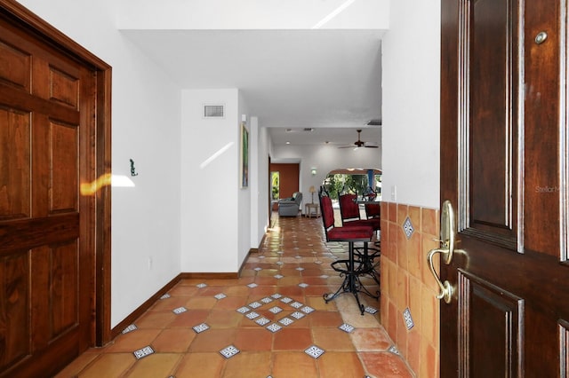 foyer with dark tile floors and ceiling fan