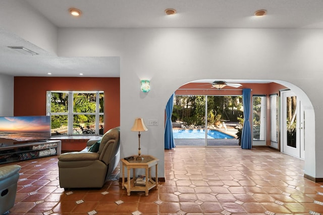 tiled living room featuring ceiling fan and a wealth of natural light