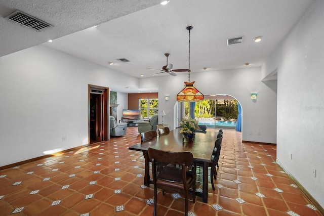 dining space with tile flooring, ceiling fan, and a textured ceiling