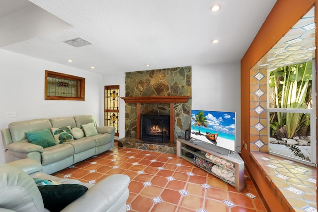 living room featuring tile floors and a stone fireplace