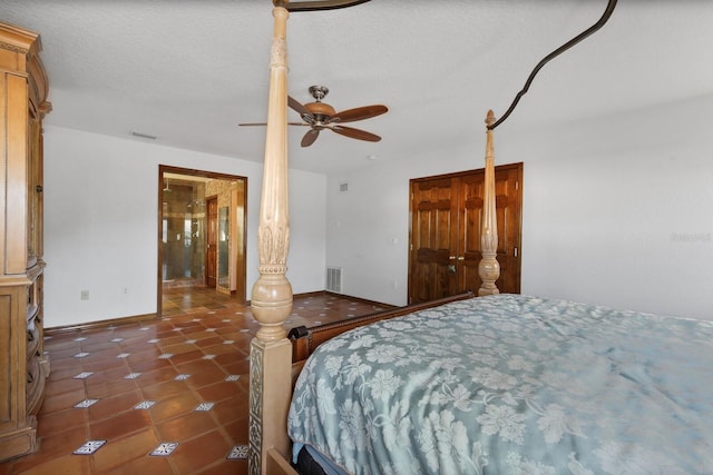 tiled bedroom with a textured ceiling and ceiling fan