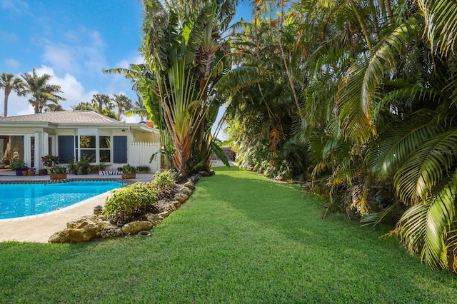 view of pool with a yard