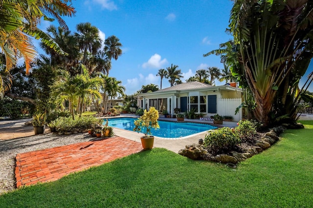 view of pool with a lawn and a patio area