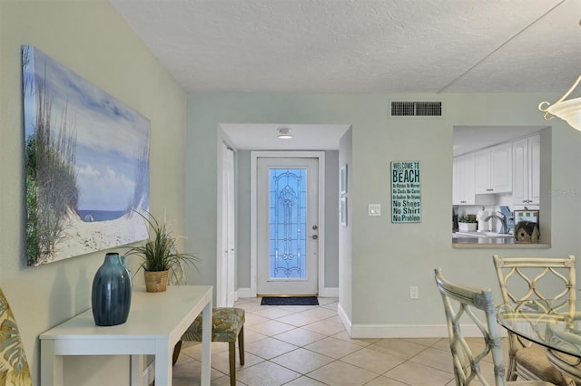 tiled entryway featuring a textured ceiling