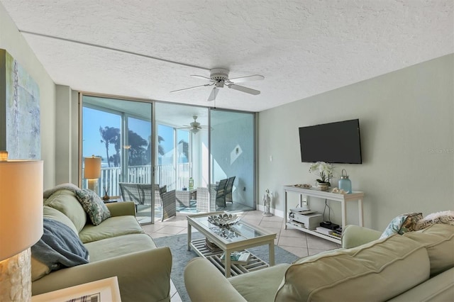 tiled living room with floor to ceiling windows, ceiling fan, and a textured ceiling