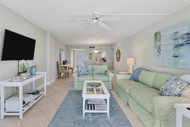 tiled living room featuring a textured ceiling and ceiling fan