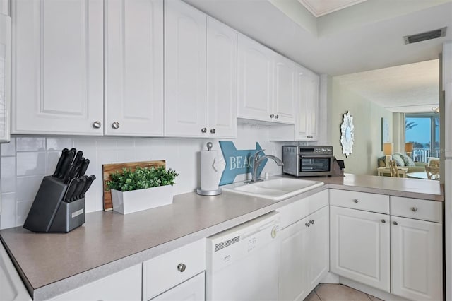 kitchen featuring backsplash, sink, white cabinetry, and white dishwasher