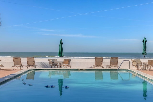 view of pool with a water view and a patio