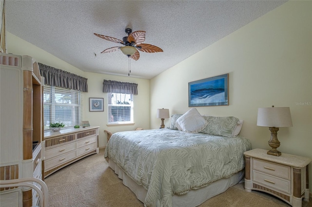 bedroom with light colored carpet, vaulted ceiling, ceiling fan, and a textured ceiling