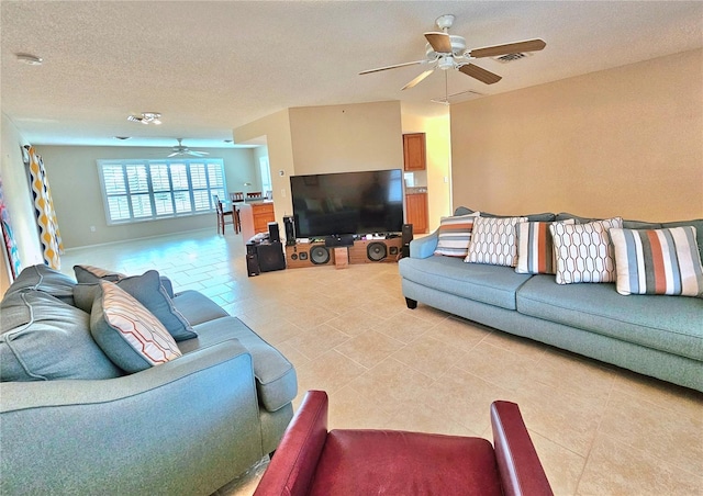 living room with a textured ceiling, ceiling fan, and light tile floors