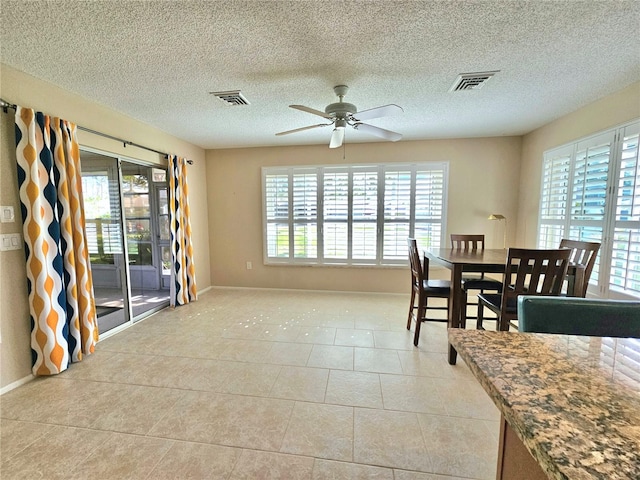 tiled dining area featuring a textured ceiling and ceiling fan